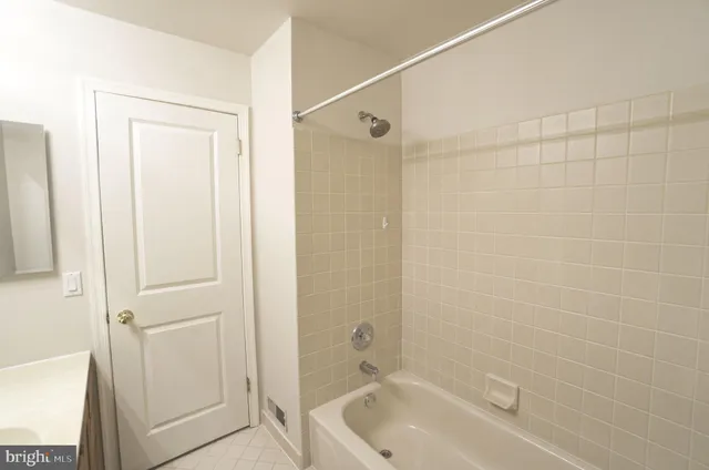 a bathroom with a tub shower and vanity