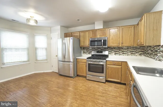 a kitchen with a refrigerator stove top oven and sink