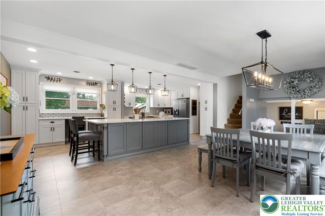 3340 Bridlepath Road Easton, PA 18045 - Photo 16 of 52 a kitchen with stainless steel appliances kitchen island granite countertop a dining table chairs and a refrigerator