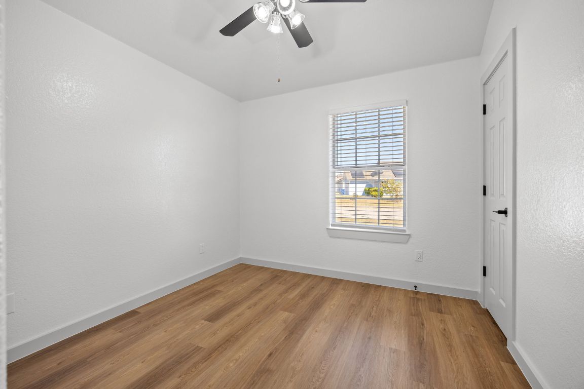 2303 Thomas Street Taylor, TX 76574 - Photo 11 of 16 wooden floor in an empty room with a window