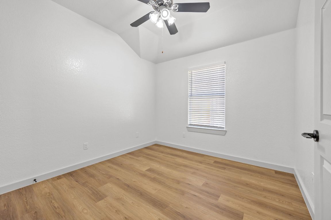 2303 Thomas Street Taylor, TX 76574 - Photo 13 of 16 wooden floor in an empty room with a window