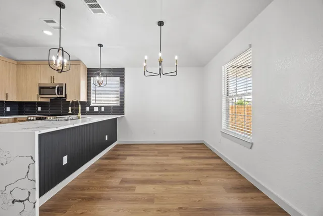 a kitchen with kitchen island granite countertop stainless steel appliances a large counter top space appliances and a window