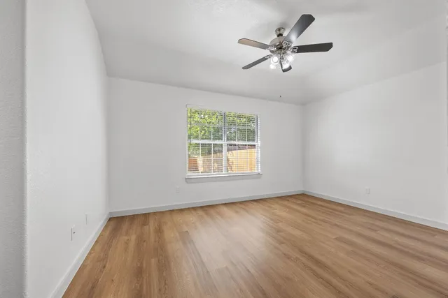 wooden floor in an empty room with a window