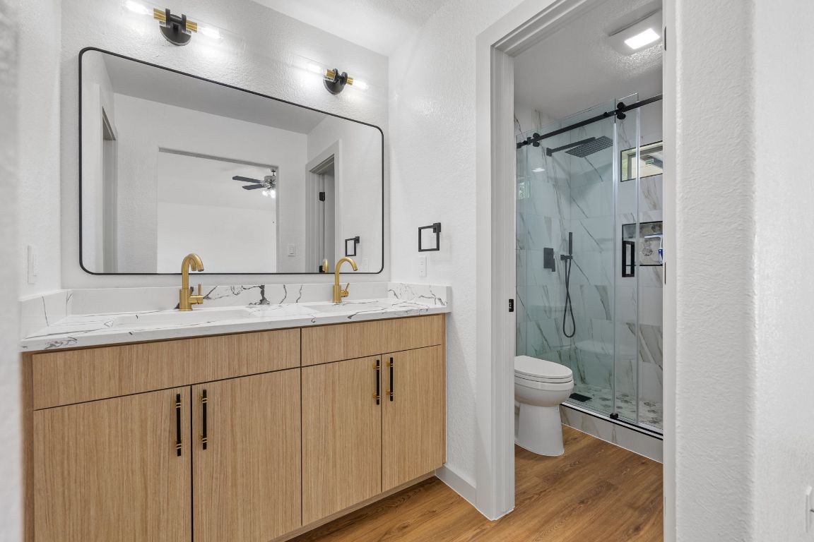 2303 Thomas Street Taylor, TX 76574 - Photo 9 of 16 a bathroom with a double vanity sink toilet mirror and shower
