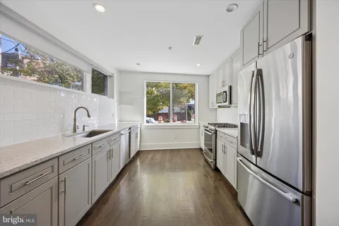 a kitchen with white cabinets and stainless steel appliances