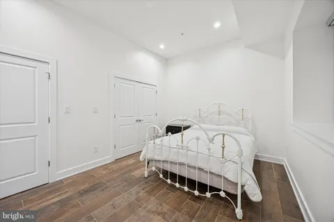 a bedroom with a bed and wooden floor