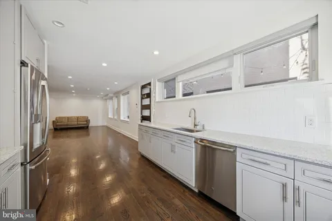 a view of a kitchen with stainless steel appliances granite countertop a sink and cabinets