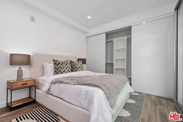 a bedroom with a bed and a lamp on dresser