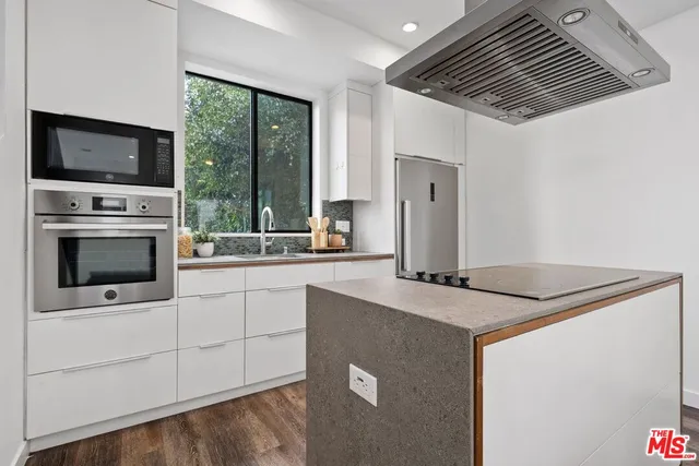 a kitchen with stainless steel appliances granite countertop a stove and a microwave