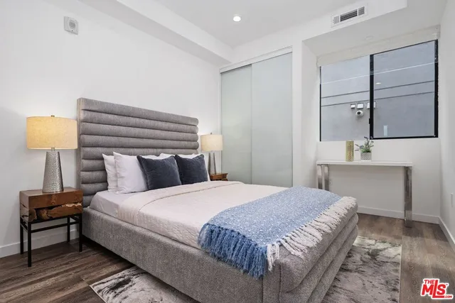 a bedroom with a bed and painting on the wall