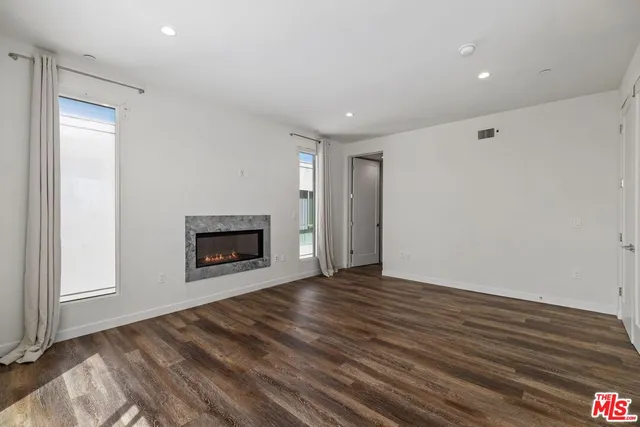 a view of an empty room with a fireplace and a window