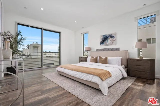 a bedroom with a large bed and a wooden floor