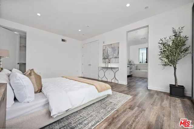a bedroom with a bed and a potted plant