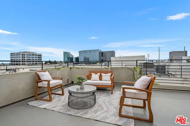 a outdoor sitting area with furniture and city view