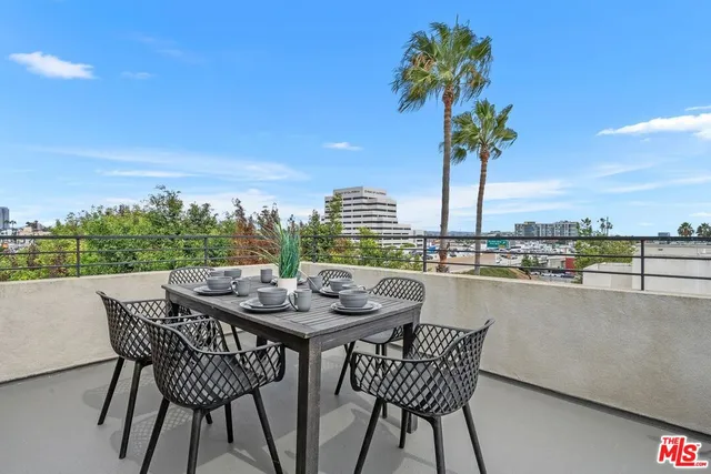a dining table on a terrace with a table and chairs
