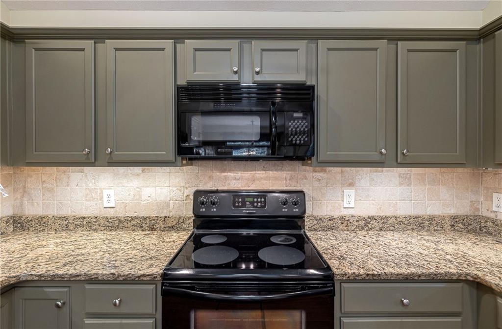 245 Memory Lane Winder, GA 30680 - Photo 18 of 62 a kitchen with granite countertop a stove top oven microwave and cabinets