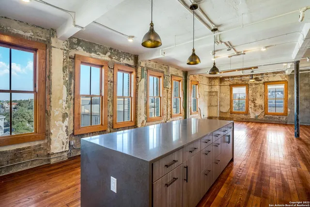 a kitchen with stainless steel appliances granite countertop a stove and wooden floors