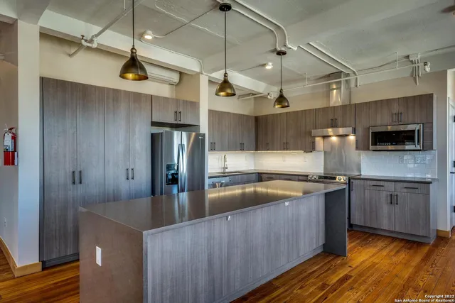 a kitchen with stainless steel appliances granite countertop a sink a stove and a refrigerator