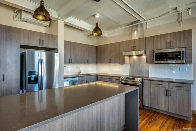 a kitchen with stainless steel appliances granite countertop a sink a stove and a microwave