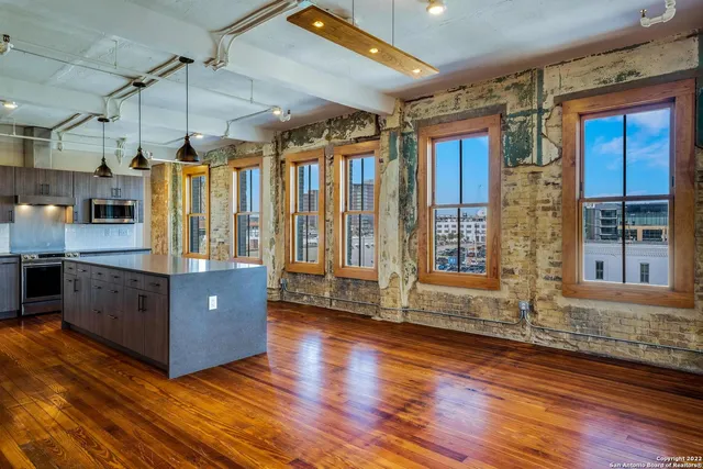 a room with wooden floors and large windows