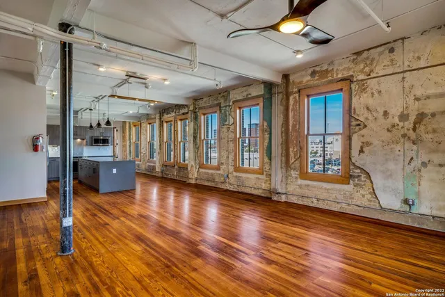 a view of a room with wooden floor and windows