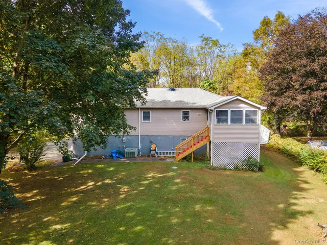 a view of a house with backyard and a tree