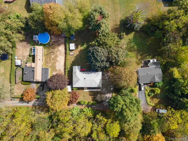a view of a street with potted plants and large trees