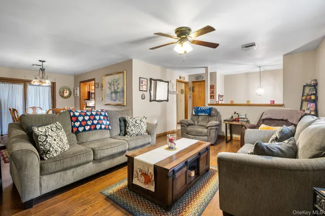 a living room with furniture a ceiling fan and a rug