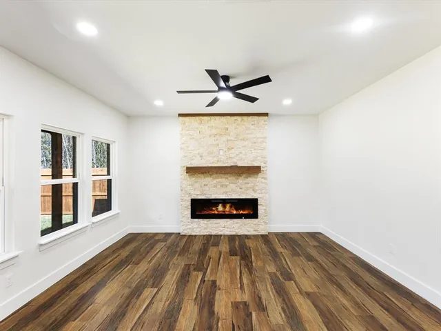 a view of an empty room with a fireplace and a window