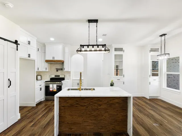a kitchen with stainless steel appliances a stove refrigerator and cabinets