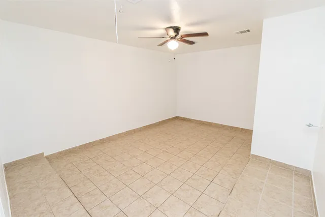 a view of a room with an empty space and a ceiling fan