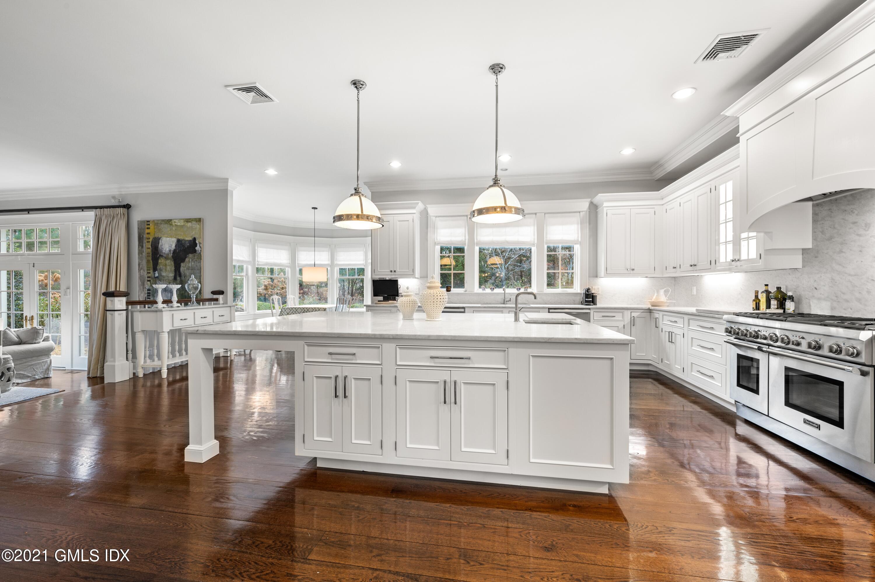 3 Hycliff Road Greenwich, CT 06831 - Photo 5 of 31 a large kitchen with kitchen island a large counter top a sink and a wooden floors