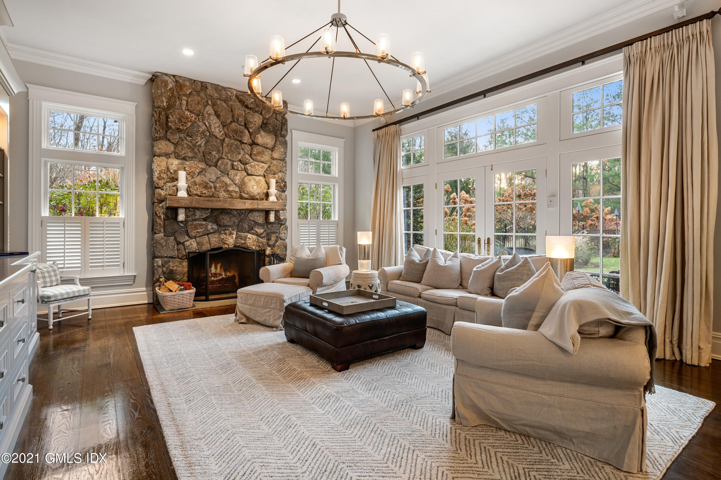 3 Hycliff Road Greenwich, CT 06831 - Photo 9 of 31 a living room with furniture a fireplace and a chandelier