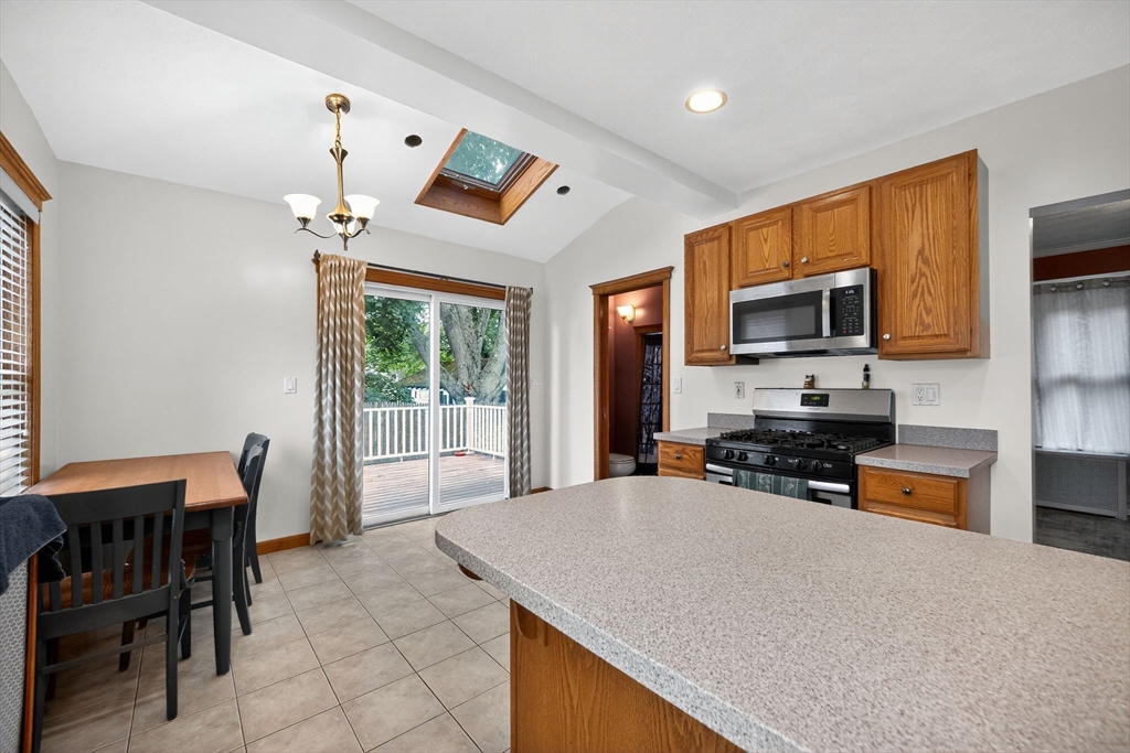 8 Corthell Road North Billerica, MA 01862 - Photo 7 of 28 a kitchen with stainless steel appliances a stove a sink a microwave a dining table and chairs
