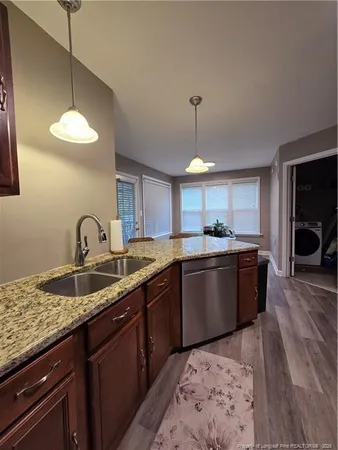 a kitchen with granite countertop a sink a counter space appliances and cabinets