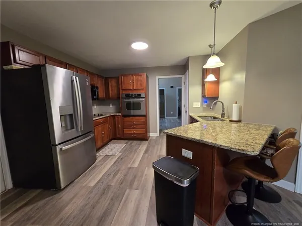 a kitchen with kitchen island a counter space a sink appliances and cabinets