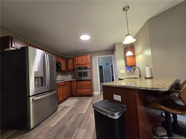 a kitchen with kitchen island a counter top space a sink stainless steel appliances and cabinets