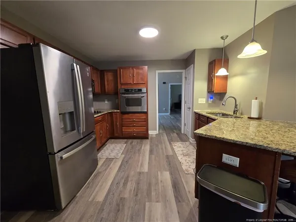 a kitchen with stainless steel appliances granite countertop a refrigerator a sink and a stove