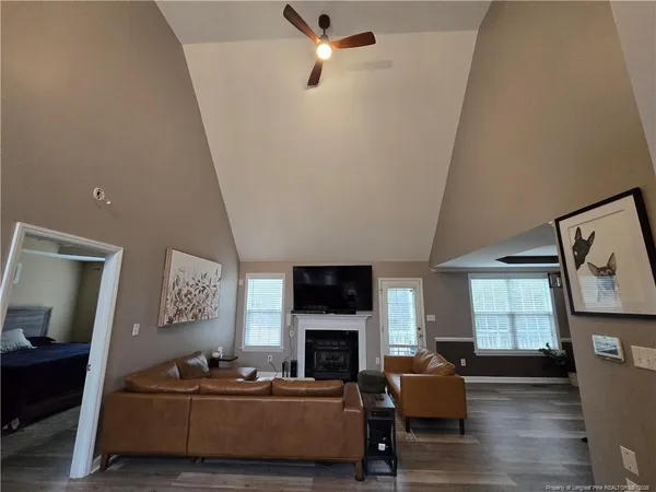 a living room with furniture a fireplace and a flat screen tv