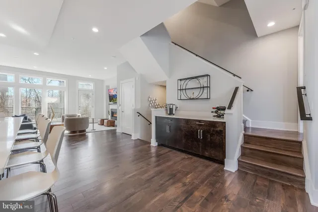 a living room with couches and kitchen view with wooden floor