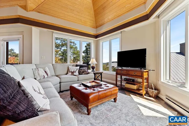 a living room with furniture a flat screen tv and a large window