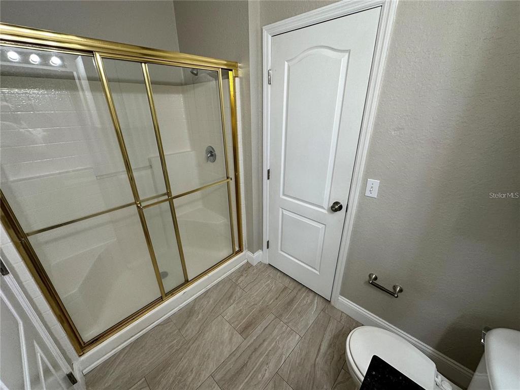 3307 South Kirkman Road, Unit 129 Orlando, FL 32811 - Photo 15 of 24 a bathroom with a glass door shower and toilet