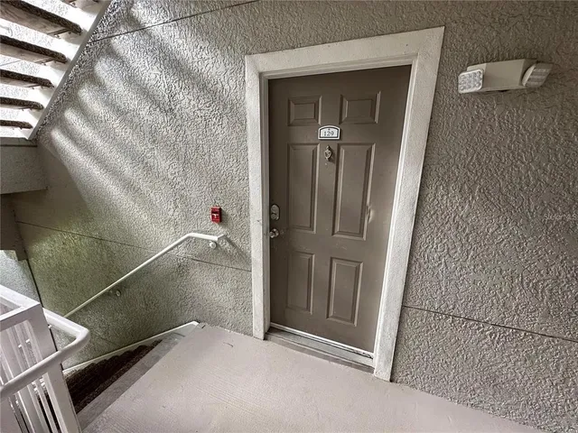 a view of a refrigerator in kitchen and an empty room