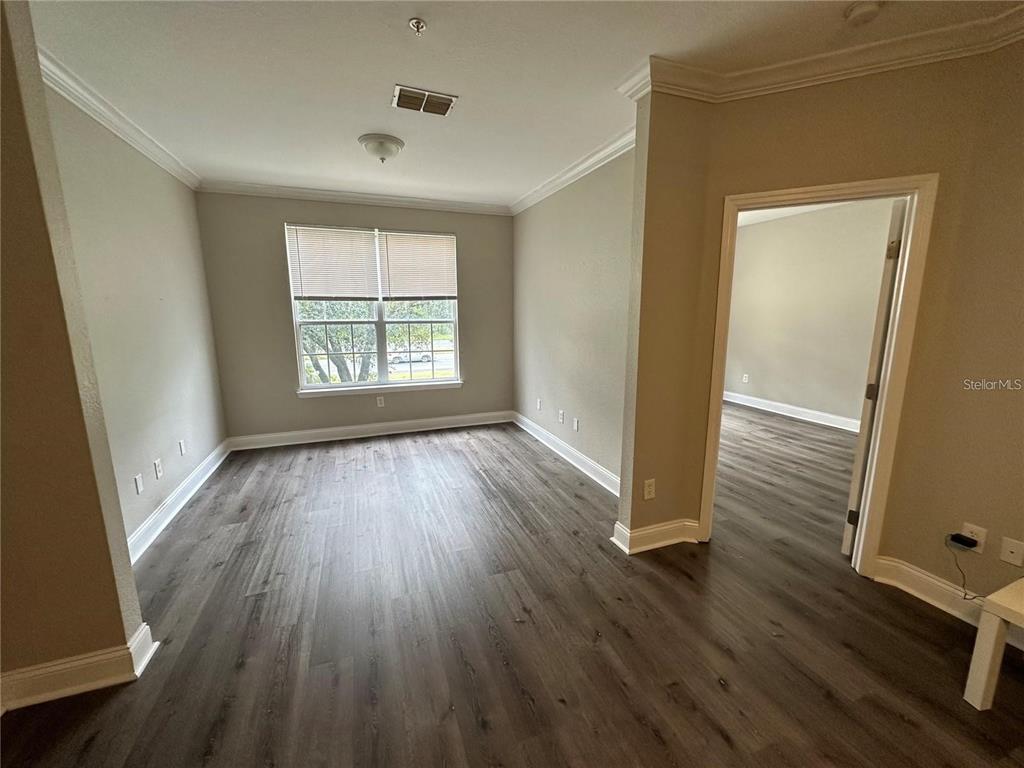 3307 South Kirkman Road, Unit 129 Orlando, FL 32811 - Photo 6 of 24 an empty room with wooden floor and windows