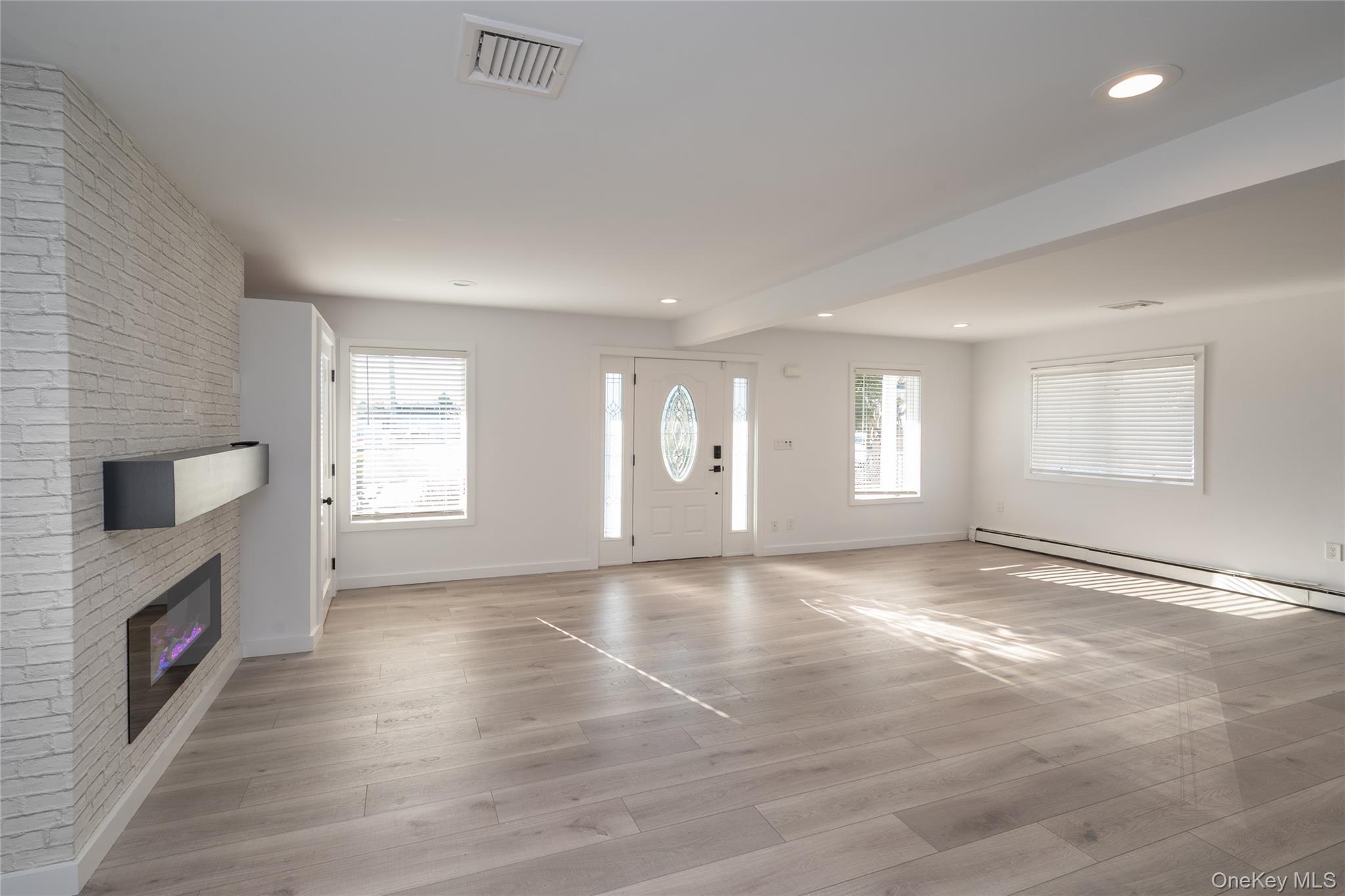 15 Roneck Court Shirley, NY 11967 - Photo 13 of 44 a view of an empty room with a window and wooden floor