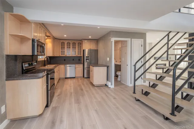 a view of a livingroom with wooden floor and stairs