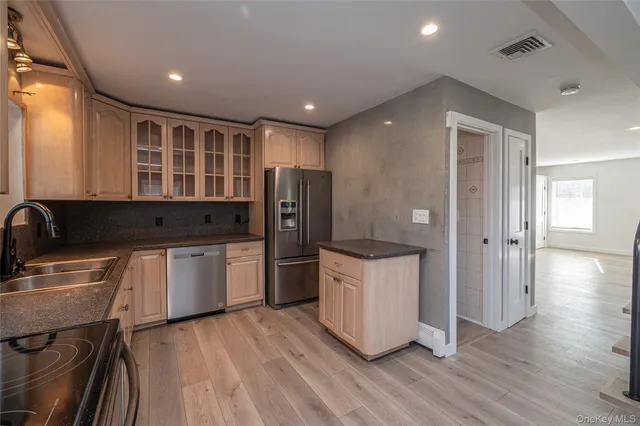 a kitchen with stainless steel appliances kitchen island granite countertop a stove a sink and a microwave