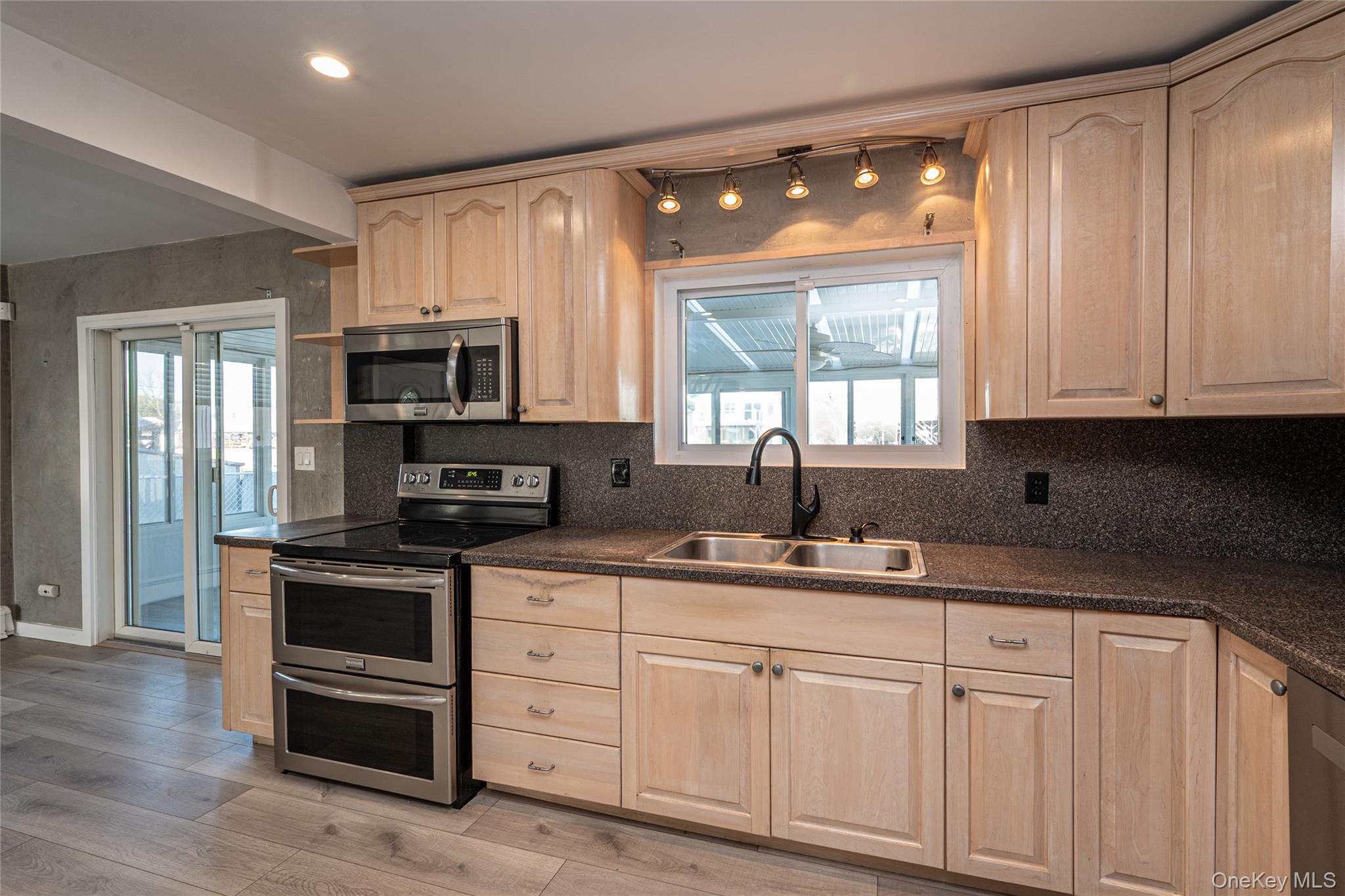 15 Roneck Court Shirley, NY 11967 - Photo 21 of 44 a kitchen with kitchen island granite countertop white cabinets and stainless steel appliances