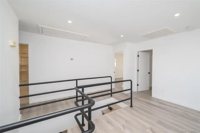 a view of a hallway with wooden floor and paintings on the walls