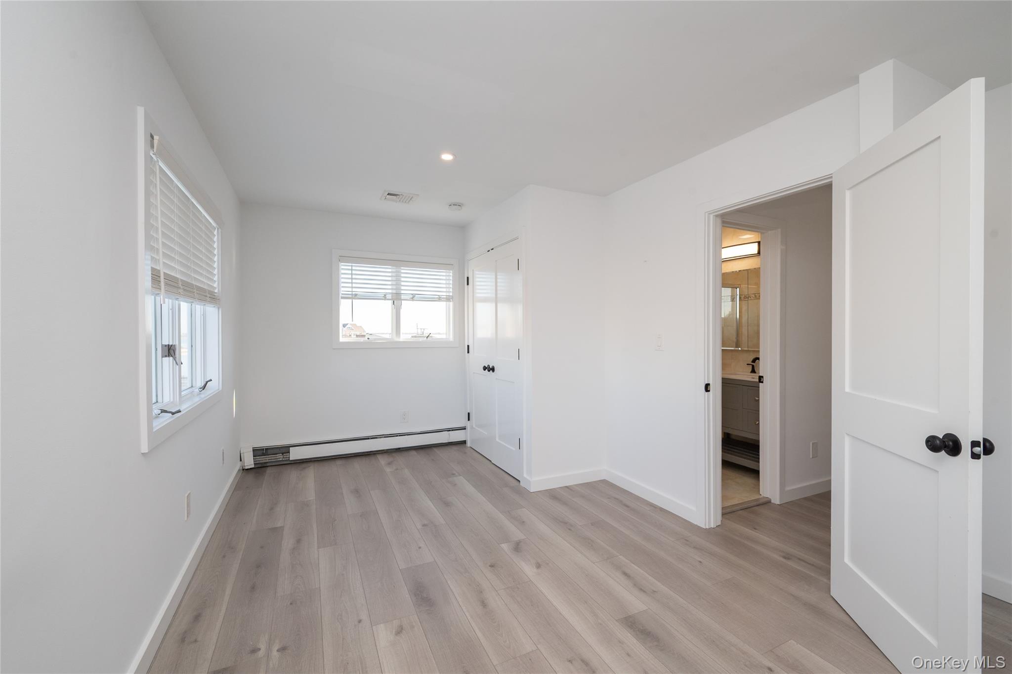 15 Roneck Court Shirley, NY 11967 - Photo 31 of 44 an empty room with wooden floor and windows